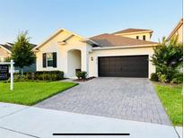 Charming single-Gathering home boasting a well-manicured lawn and a two-car garage with a paved driveway at 4418 Lions Gate Ave, Clermont, FL 34711