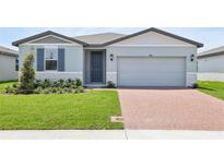 Charming single-story home with a well-manicured lawn and brick driveway leading to a two-car garage at 4544 Windy Oak Way, St Cloud, FL 34772