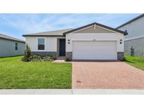 Charming home featuring a brick driveway, two-car garage, and manicured lawn at 4550 Windy Oak Way, St Cloud, FL 34772