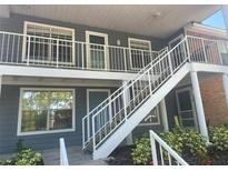 Charming two-story condo with light gray siding and white railings on the stairs and balconies at 5417 Lake Margaret Dr # 39, Orlando, FL 32812