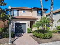 Charming two-story home featuring a tile roof, two-car garage, and tasteful landscaping at 5528 Solterra Cir, Davenport, FL 33837