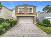 Inviting home featuring an attached two-car garage and a brick paver driveway at 7407 Excitement Dr, Reunion, FL 34747