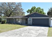 Charming single-story home with gray stone exterior and attached garage under a bright blue sky at 122 W Hillcrest St, Altamonte Springs, FL 32714
