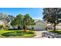 Charming single-story home features a manicured lawn and mature shade trees at 12712 Forestedge Cir, Orlando, FL 32828