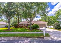 Charming single-story home featuring a well-manicured lawn, mature trees, and a two-car garage at 1272 Mount Logan Dr, Apopka, FL 32712