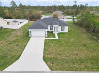 New construction featuring a well-manicured lawn and concrete driveway leading to an attached two-car garage at 16121 Sw 37Th Terrace Rd, Ocala, FL 34473