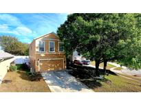 Two-story home with a two-car garage and a large tree in the front yard providing ample shade at 25012 Chipshot Ct, Sorrento, FL 32776