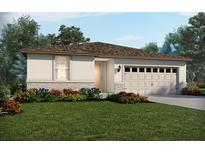 Inviting single-story home with a two-car garage, stone accents, and beautifully landscaped front yard at 305 Castle Dr, Lake Alfred, FL 33850