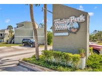 Winter Park Woods Condominium entrance sign with tropical landscaping and modern building in the background at 336 Scottsdale Sq # 336, Winter Park, FL 32792