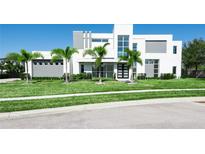 Modern two-story home featuring a geometric design, tall windows, and meticulously maintained landscaping with palm trees at 6106 Marleon Dr, Windermere, FL 34786