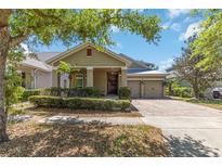 Charming single-story home with a brick driveway, a well-manicured lawn, and a two-car garage at 6799 Helmsley Cir, Windermere, FL 34786