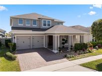 Charming two-story home featuring a well-manicured lawn, covered porch, and a convenient two-car garage at 7131 Desert Mandarin St, Winter Garden, FL 34787
