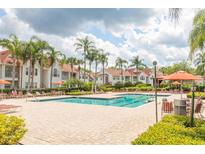 Community pool and deck surrounded by lush landscaping and lounge chairs at 11562 Westwood Blvd # 934, Orlando, FL 32821