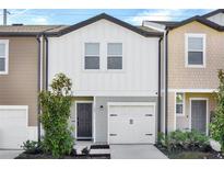 Charming townhome features a modern facade, garage, and well-maintained landscaping at 125 Mandovi St, Davenport, FL 33837