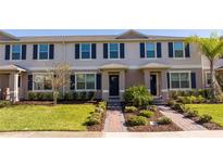 Charming townhome featuring a landscaped front yard and classic architectural details like shutters and a covered entry at 17101 Water Spring Blvd, Winter Garden, FL 34787