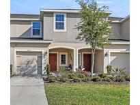 Two-story townhome featuring a well-maintained lawn, lovely landscaping, and individual driveways at 2087 Crystal Bell St, Orlando, FL 32824