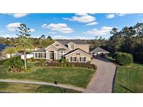 Stunning two-story home featuring lush landscaping, a porte-cochere, and a brick paved driveway at 3138 Lee Shore Loop, Orlando, FL 32820