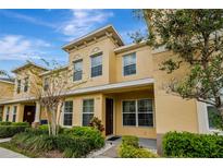 Inviting exterior of a two-story townhome featuring manicured landscaping and a warm, neutral color palette at 5481 Limestone Ln # 5481, Lakeland, FL 33809