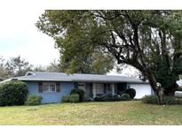 Charming single-story home with blue siding, shutters, and a well-manicured lawn at 63 Dahlia Dr, Debary, FL 32713