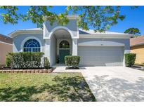 Charming single-story home showcasing a well-manicured lawn and a welcoming arched entryway at 908 Jade Forest Ave, Orlando, FL 32828