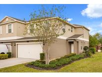 Charming townhouse with landscaped front yard, two-car garage and neutral-colored stucco at 15143 Pacey Cove Dr, Orlando, FL 32824