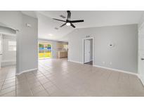Open-concept living area boasts tile flooring, neutral paint, and sliding glass doors to the backyard at 177 Larch Rd, Ocala, FL 34480