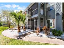 Gray condo building with white rock landscaping and exterior staircase leading to second floor at 203 Northlake Dr, Sanford, FL 32773