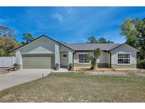 Charming single-story home featuring a well-manicured lawn, attached garage, and inviting front entrance at 209 Roman Ct, Deltona, FL 32738