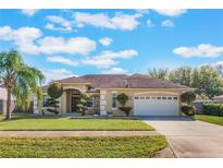 Charming single-story home features a well-manicured lawn, mature trees and a two car garage at 2361 Baker Ave, Orlando, FL 32833