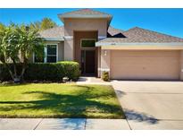 Inviting single-Gathering home featuring a well-manicured lawn, mature landscaping, and an attached two-car garage at 2519 Cypress Trace Cir, Orlando, FL 32825