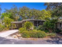 Charming home featuring a carport, mature landscaping, and a screened-in porch for outdoor living at 410 N Niblick Ln, Lake Mary, FL 32746