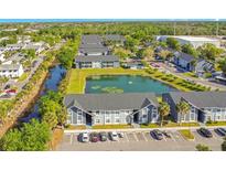 Condominium community with landscaped grounds and a tranquil pond at 4314 Pershing Pointe Pl # 4, Orlando, FL 32822
