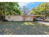 Charming single-story home featuring a covered carport with a boat on a trailer at 5386 Mustang Way, Orlando, FL 32810