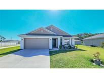 Charming single-story home with a well-manicured lawn, two-car garage and neutral color palette at 644 Hudson Valley Dr, Kissimmee, FL 34759