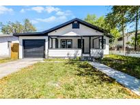 Charming single Gathering home showcasing a well-manicured lawn, garage, and cozy front porch at 819 State Ave, Daytona Beach, FL 32117