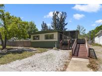 Charming single-story home featuring a ramp to the screened porch and well-kept landscaping at 831 Wolf Trl, Casselberry, FL 32707