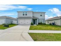 Charming two-story home features a two-car garage, manicured lawn, and a welcoming front entrance at 1506 Finnigan Cir, Haines City, FL 33844