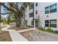 Modern townhome shows striking elevation with mature tree, neutral colors, and inviting front entrance at 1602 Park Lake St # 2, Orlando, FL 32803
