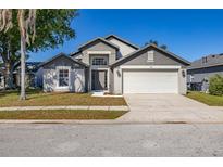 Charming two-story home featuring a well-manicured lawn, attached two-car garage and appealing curb appeal at 165 Margate Dr, Davenport, FL 33897