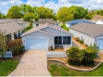 Charming single-story home with a well-manicured lawn, white picket fence, and attached one car garage at 790 Blake Ln, The Villages, FL 32162