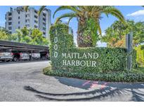 Community signage at 1000 Maitland Harbour, beautifully landscaped with lush greenery and mature palms near covered parking at 1000 S Orlando Ave # 4, Maitland, FL 32751