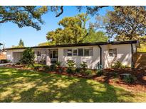 Charming single-story home with a mix of siding and brick accents, complemented by a beautifully landscaped front yard at 3903 Mockingbird Ln, Orlando, FL 32803