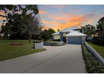 Stunning two-story home with a gray exterior, a white metal roof and an expansive driveway at 5243 W Lake Butler Rd, Windermere, FL 34786