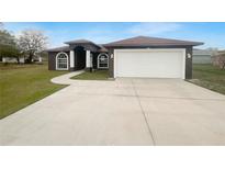 Charming single-story home featuring an attached garage, arched windows, and a well-maintained lawn at 546 Koala Dr, Kissimmee, FL 34759