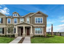 Inviting townhome with a two-story facade, manicured lawn, and charming front porch at 6633 Calamondin Dr, Winter Garden, FL 34787