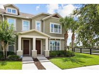 Charming home exterior featuring a well-maintained lawn, inviting entryway, and beautiful palm trees at 6633 Calamondin Dr, Winter Garden, FL 34787