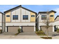 Charming townhome featuring a two-car garage and modern architectural details at 10359 Ebb Tide Ln, Orlando, FL 32821