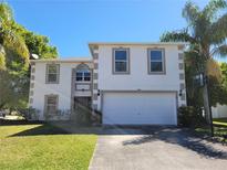 Inviting two-story home featuring an attached two-car garage and well-maintained lawn at 115 Royalty Cir, Sanford, FL 32771