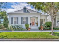 Charming white home with gray shutters, landscaped yard, and a red front door exudes curb appeal at 1582 Almond Ave, Orlando, FL 32814