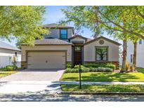 Charming two-story home featuring a brick driveway, attached garage, and well-manicured landscaping at 2224 Romanum Dr, Winter Garden, FL 34787